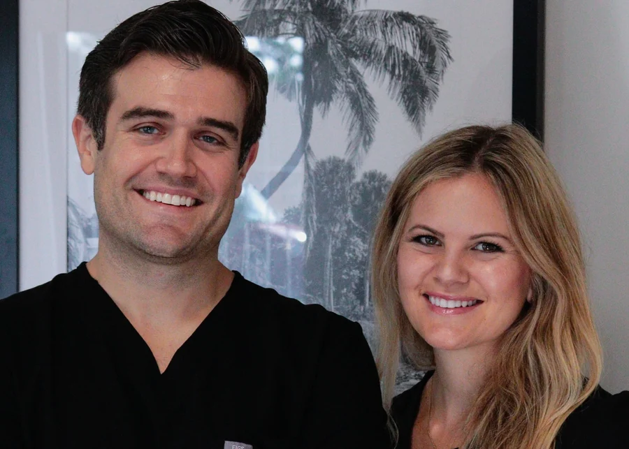 Dr. Shane Vaughn and Dr. Amiee Vaughn, smiling, in the office.