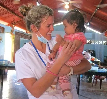 Dr. Amiee with a patient’s baby on a service trip to Nicaragua.