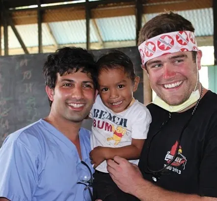 Dr. Shane with another volunteer and a young patient in the Philippines.