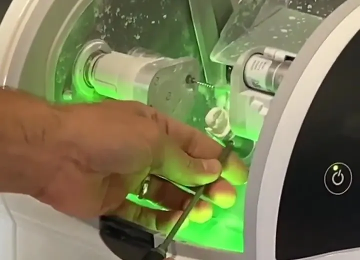 The CEREC milling unit in the office, cutting a porcelain crown.